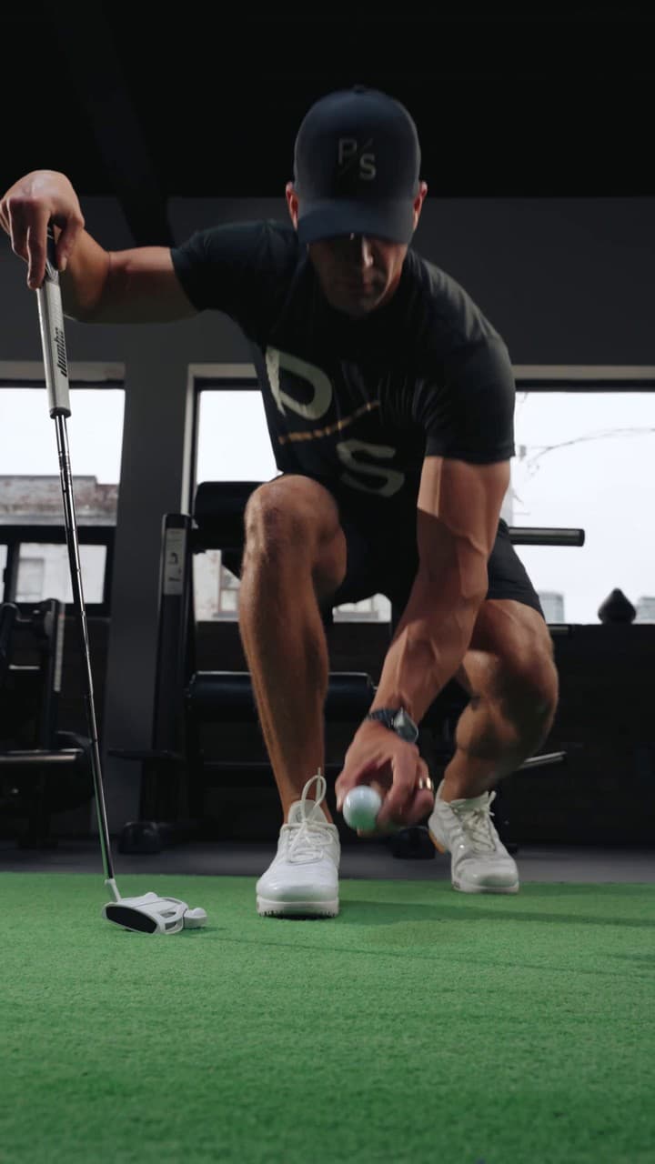 Chris Karagitsis setting up to a golf ball on indoor turf
